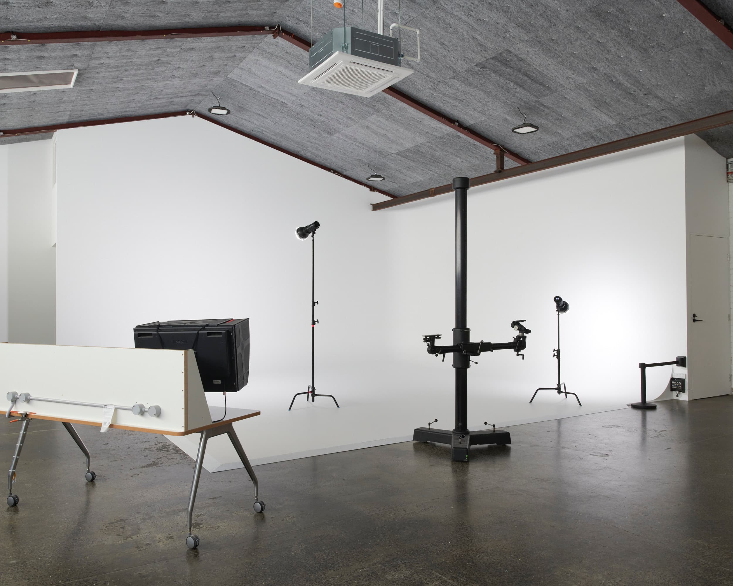 Studio A cyclorama from the side with a camera stand, monolight and client monitor