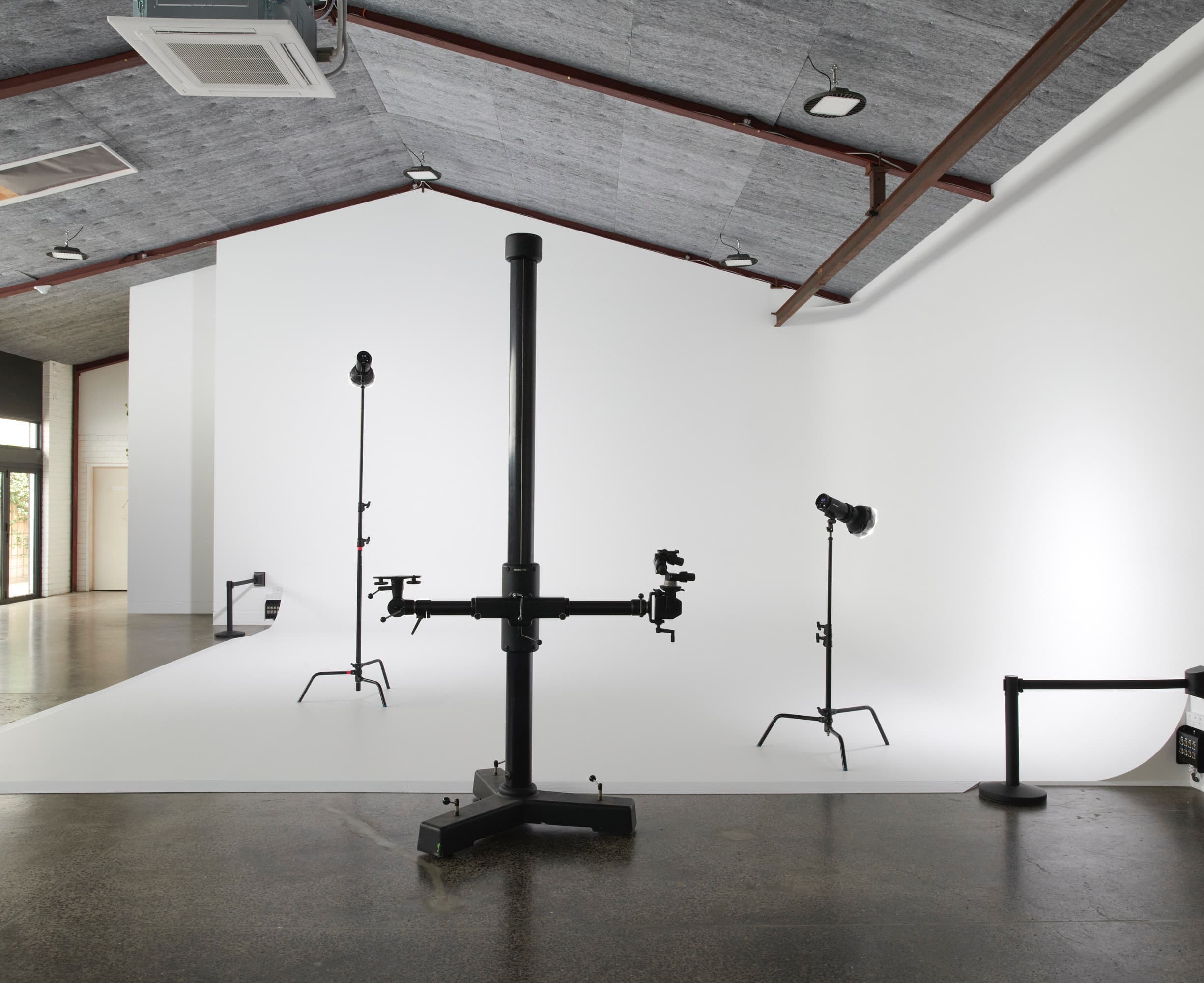 Studio A at Crate Studio — a white 7-metre cyclorama with a camera stand and two lights under a grey acoustic ceiling